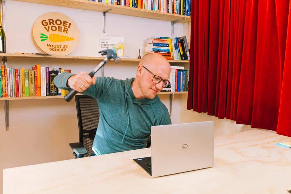 Gerhard te Velde die met een hamer op zijn laptop gaat slaan