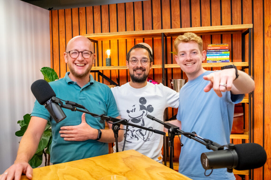 Drie lachende mannen, waaronder Bas Verhoeven en Lars Lensink, staan samen voor microfoons in de studio van de Groeivoer Podcast.