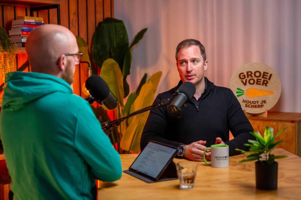 Twee mannen in gesprek achter microfoons tijdens een opname van de Groeivoer Podcast met Lars Lensink.