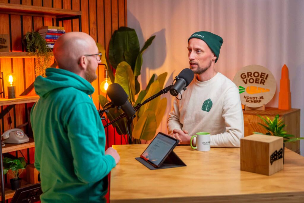 Twee mannen in gesprek tijdens een opname van de Groeivoer-podcast in een kleurrijke studio.