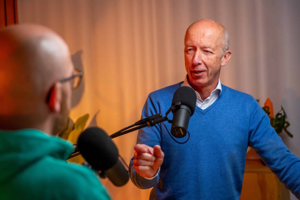 Man in blauwe trui spreekt in microfoon tijdens een opname van de Groeivoer Podcast met Lars Lensink.