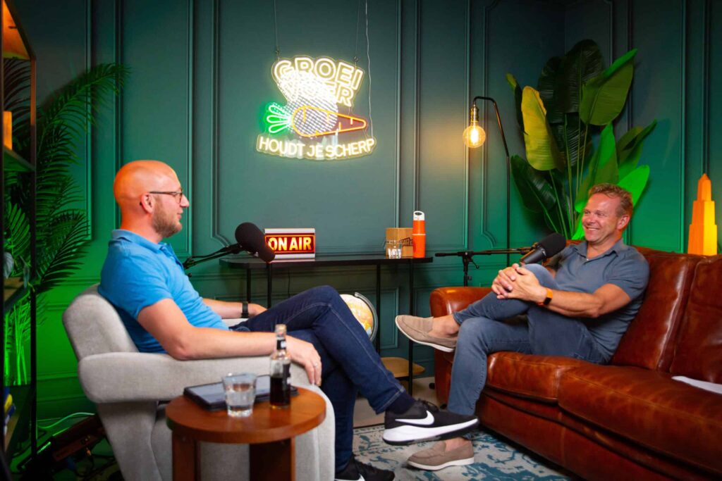 Twee mannen voeren een gesprek tijdens een opname van de Groeivoer-podcast in een kleurrijke studio.