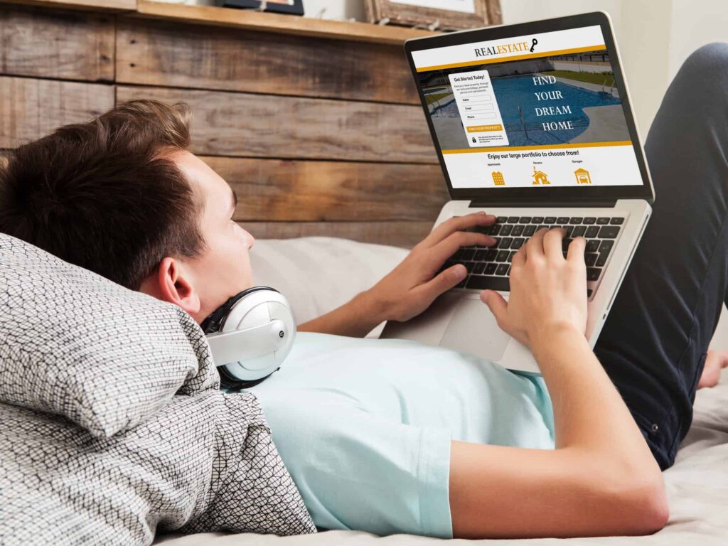 Jongen ligt op bed met laptop op schoot terwijl hij werkt aan een website.